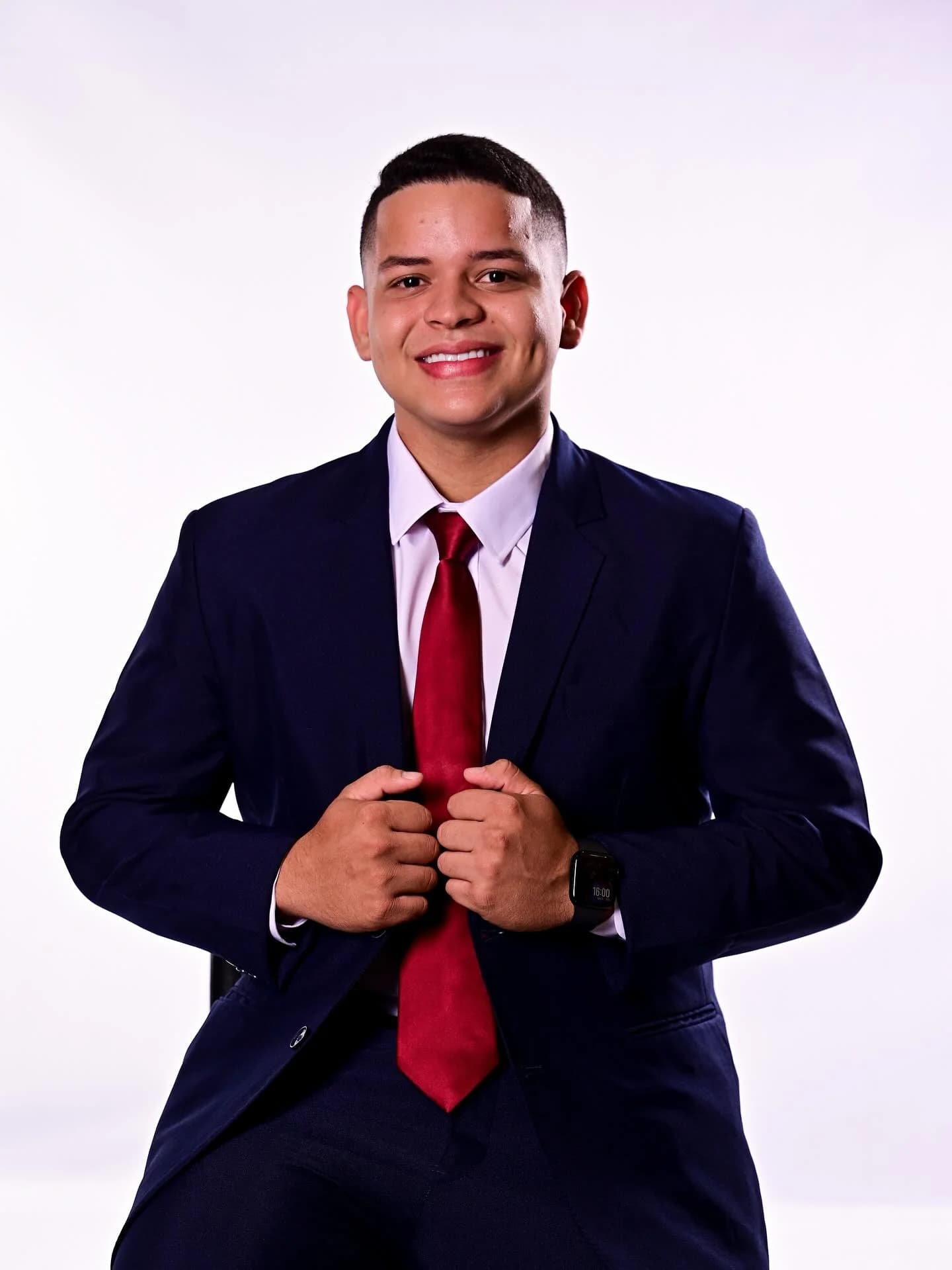 Eric Ferraz de frente, vestindo terno azul-marinho e gravata vermelha.